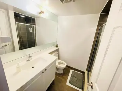 a bathroom with a white sink and a toilet at 2 Bedroom Luxury Suite Across Square One in Mississauga