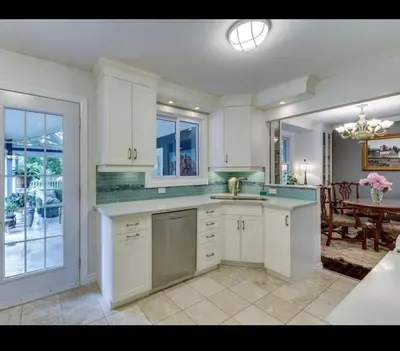a large kitchen with white cabinets and a dining room at Grimsby Lake Front Home in Grimsby