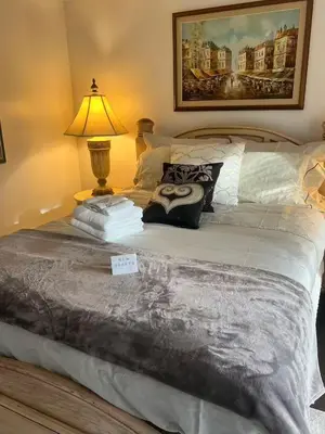 a bedroom with a bed with a lamp on it at Grimsby Lake Front Home in Grimsby