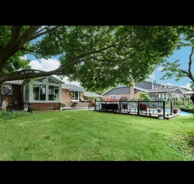 a house with a large yard with a large lawn at Grimsby Lake Front Home in Grimsby