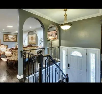 a living room with a staircase and a room with a stair case at Grimsby Lake Front Home in Grimsby