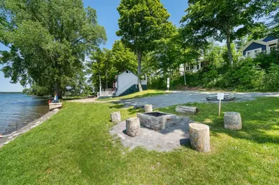a picnic area on the shore of a lake with trees at The Bluebird - 7 Summer Village in Cherry Valley
