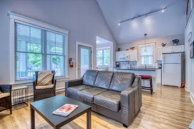 a living room with a couch and a kitchen at The Bluebird - 7 Summer Village in Cherry Valley