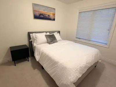 a bedroom with a white bed with a window at Serenity Home in Brampton in Brampton