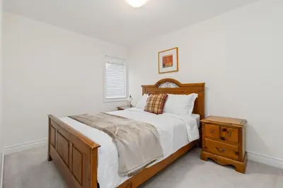 a bedroom with a wooden bed and a night stand at Serenity Home in Brampton in Brampton