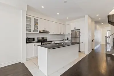 a kitchen with white cabinets and a black counter top at Serenity Home in Brampton in Brampton