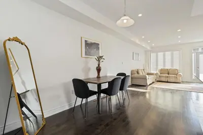 a dining room with a table and chairs and a living room at Serenity Home in Brampton in Brampton