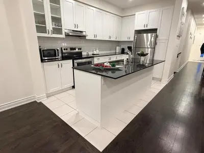 a kitchen with white cabinets and a black counter top at Serenity Home in Brampton in Brampton