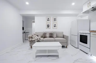 a white living room with a couch and a table at Bright Modern 1BR Suite Kitchen Workspace Smart TV in Bowmanville