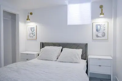 a white bedroom with a bed with two night stands at Bright Modern 1BR Suite Kitchen Workspace Smart TV in Bowmanville
