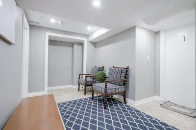 a hallway with two chairs and a potted plant at Bright Modern 1BR Suite Kitchen Workspace Smart TV in Bowmanville