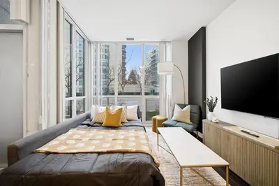 a bedroom with a bed and a large window at Lux Harbourfront Home Sleeps 10 with Free Parking in Toronto
