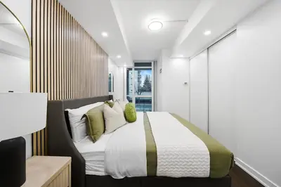 a bedroom with a large bed with white and green pillows at Lux Harbourfront Home Sleeps 10 with Free Parking in Toronto