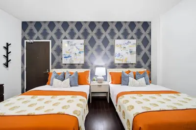two beds in a room with orange and blue at Lux Harbourfront Home Sleeps 10 with Free Parking in Toronto
