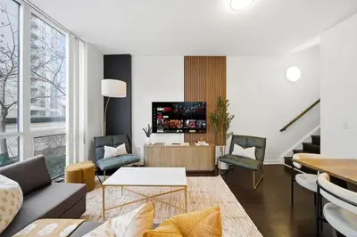 a living room with a couch and a tv at Lux Harbourfront Home Sleeps 10 with Free Parking in Toronto