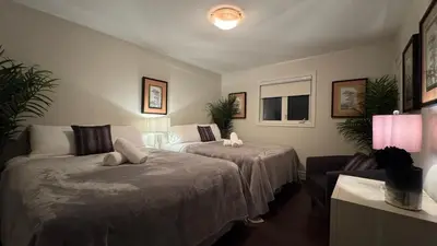 a bedroom with two beds and a table and a lamp at Executive Luxury Stay Corporate Paradise in South Richvale in Richmond Hill