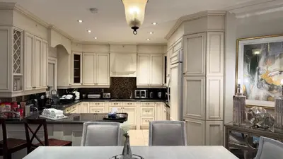 a kitchen with white cabinets and a table and chairs at Executive Luxury Stay Corporate Paradise in South Richvale in Richmond Hill