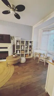 a living room with a ceiling fan and a table at Grimsby on the Lake sweet, your perfect retreat in Grimsby