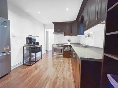 a kitchen with wooden cabinets and a counter top at Executive Urban Retreat in Brampton