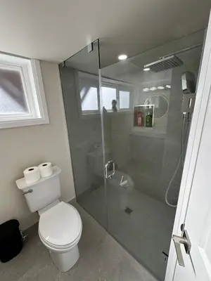 a bathroom with a toilet and a glass shower at Modern 2 bedrooms 1 bath updated unit Near Downtown Kitchener & Airport in Kitchener