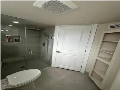 a bathroom with a toilet and a shower and a door at Modern 2 bedrooms 1 bath updated unit Near Downtown Kitchener & Airport in Kitchener