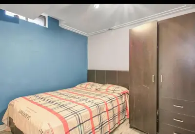 a small bedroom with a bed and a cabinet at A very peaceful home in Oshawa