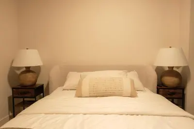 a bedroom with a bed with two lamps on both sides at Nova Luxury suites in Toronto
