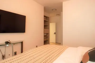 a bedroom with a flat screen tv on the wall at Nova Luxury suites in Toronto