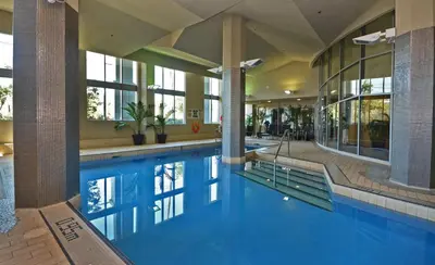 a large swimming pool in a building with a pool at Nova Luxury suites in Toronto