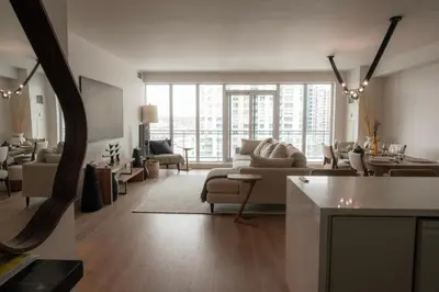 a living room filled with furniture and a large window at Nova Luxury suites in Toronto