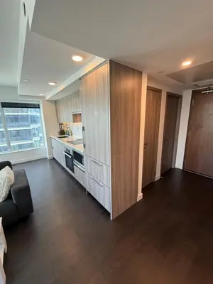 a living room with a couch and a kitchen at Luxury Condo Downtown Toronto in Toronto