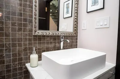 a bathroom with a white sink and a mirror at Winter Deal! Modern 4BR w/Parking, Prime Location in Toronto