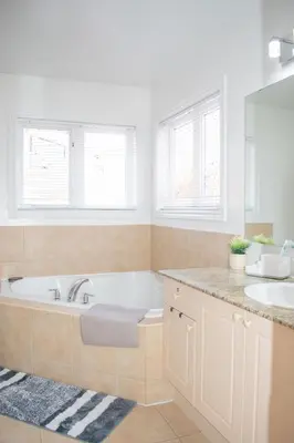 a bathroom with a tub and a sink and two sinks at Karibu Home Retreat, 5 min to Ontario Largest Spa in Ajax
