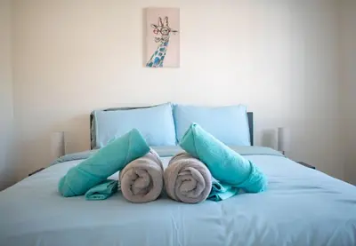 a bed with two towels and two pillows on it at Karibu Home Retreat, 5 min to Ontario Largest Spa in Ajax