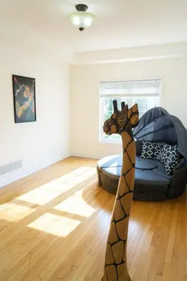 a toy giraffe in a room with a bed at Karibu Home Retreat, 5 min to Ontario Largest Spa in Ajax