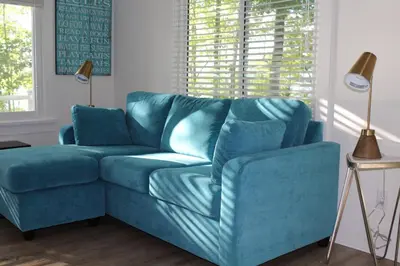 a blue couch sitting in a living room at Prime Waterfront Cottage on Sandbanks Area Resort in Cherry Valley