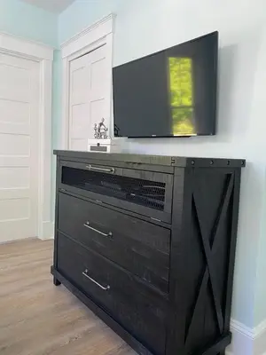 a black dresser with a television on top of it at Prime Waterfront Cottage on Sandbanks Area Resort in Cherry Valley