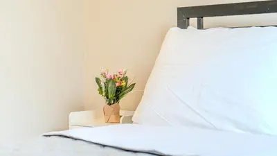 a bed with a pillow and a vase of flowers at Lakeview Willow Bay Cottages in Harwood in Harwood