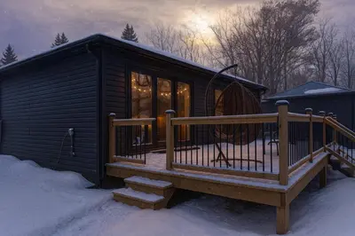 a cabin with a deck in the snow at Lakeview Willow Bay Cottages in Harwood in Harwood