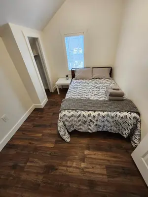 a bedroom with a bed and a wooden floor at Getaway by the bay in Owen Sound