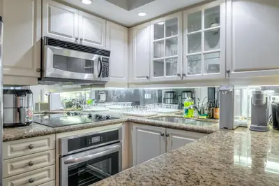 a kitchen with white cabinets and stainless steel appliances at Downtown 1BR Condo w/ Balcony & Gym Access in Toronto