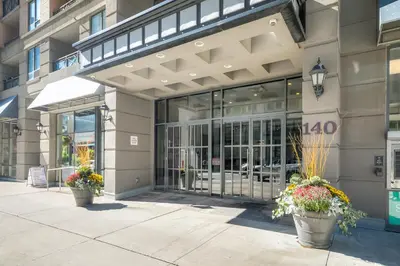 a building with two potted plants in front of it at Downtown 1BR Condo w/ Balcony & Gym Access in Toronto