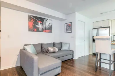 a living room with a couch and a chair at Downtown 1BR Condo w/ Balcony & Gym Access in Toronto