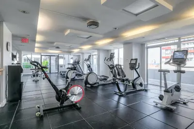 a gym with treadmills and exercise bikes in a building at Downtown 1BR Condo w/ Balcony & Gym Access in Toronto