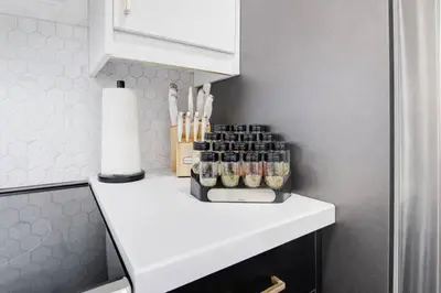 a counter with a shelf with bottles of spices at 5 bedrooms for large groups near the falls in Port Colborne