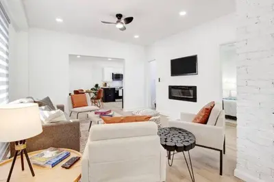 a living room with white furniture and a white brick wall at 5 bedrooms for large groups near the falls in Port Colborne