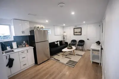 a kitchen and living room with a refrigerator and a table at 2 Bed Newly Renovated unit near Falls and Buffalo in Port Colborne