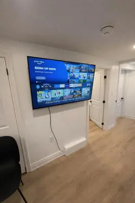 a flat screen tv hanging on a wall in a room at 2 Bed Newly Renovated unit near Falls and Buffalo in Port Colborne