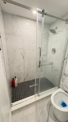 a shower with a glass door in a bathroom at 2 Bed Newly Renovated unit near Falls and Buffalo in Port Colborne