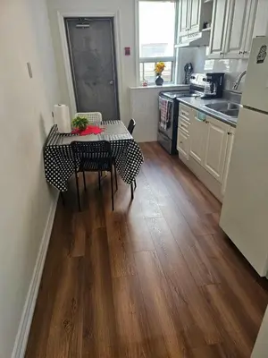 a kitchen with a table and a kitchen with a refrigerator at Central Signature Stay Downtown-Direct Transit to BMO Field Union & Free Wifi in Toronto
